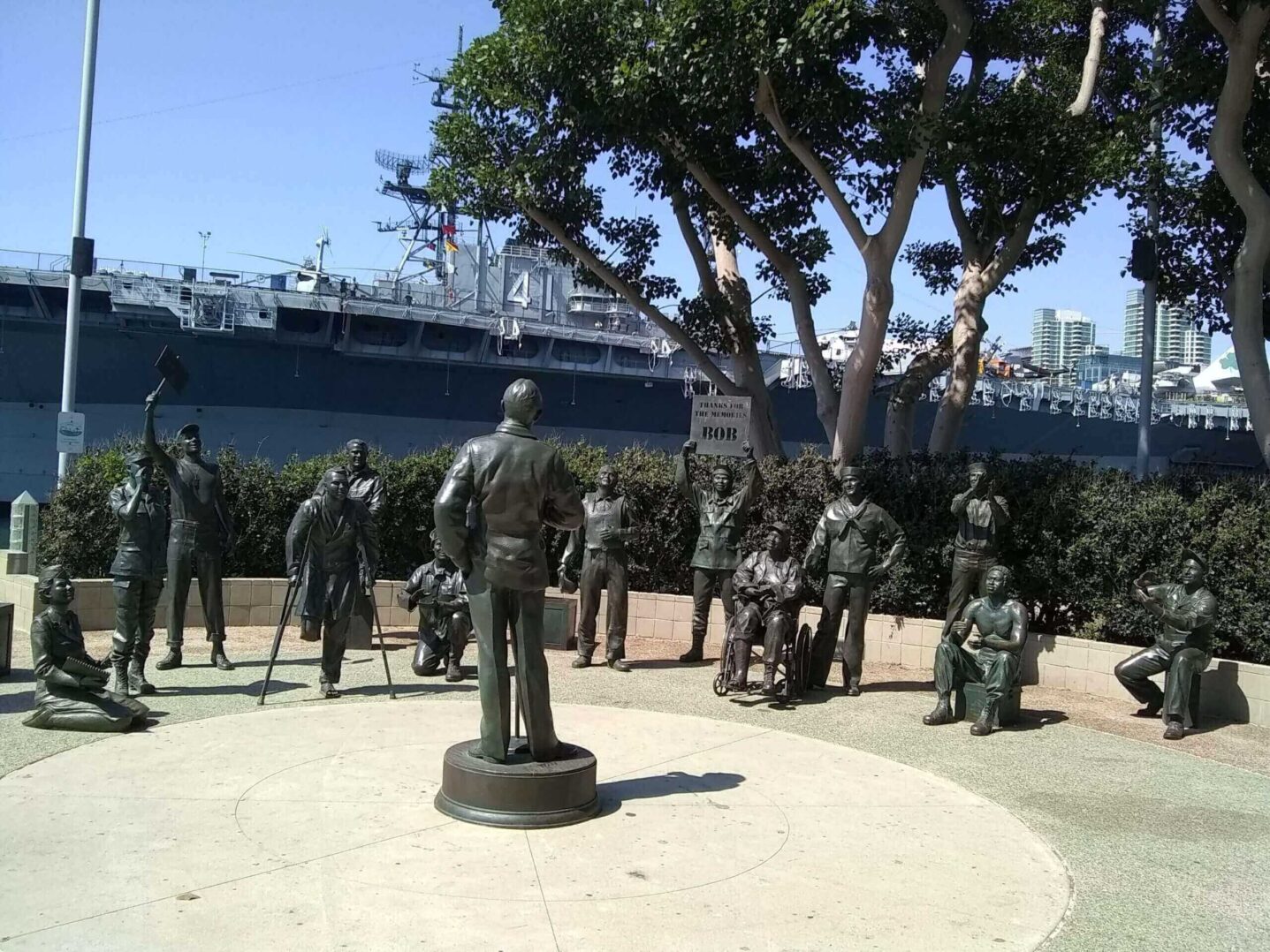 Statues of people in a circle outdoors.